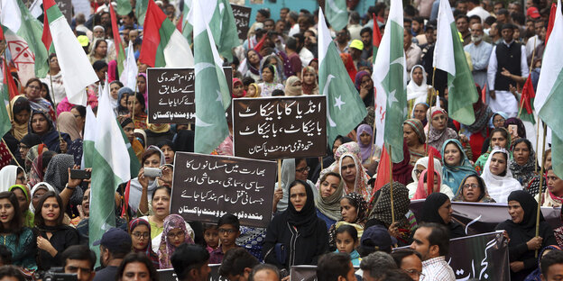 Viele Menschen tragen pakistanische Flaggen und Plakate gegen Indien Viele Menschen tragen pakistanische Flaggen und Plakate gegen Indien