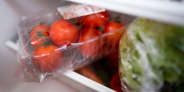 In Plastik gehüllte Tomaten und Salat In Plastik gehüllte Tomaten und Salat