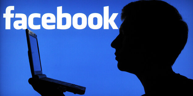 Silhouette eines Menschen, der in ein Laptop guckt Silhouette eines Menschen, der in ein Laptop guckt