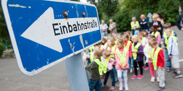 Einbahnstraßenschild und wartende Kinder Einbahnstraßenschild und wartende Kinder