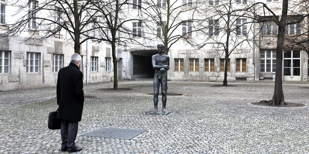 Geplasterter Hof mit Skulptur und Häusern Geplasterter Hof mit Skulptur und Häusern