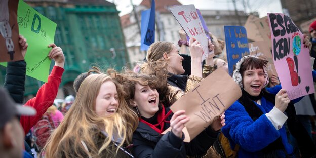 schülerinnen und schüler demonstrieren in berlin bei der demo "fridays for future". sie halten plakate hoch.