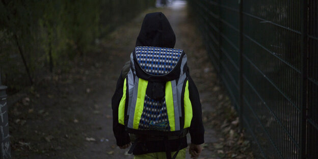 Schülerin mit leuchtendem Schulranzen auf dem Weg zur Schule Schülerin mit leuchtendem Schulranzen auf dem Weg zur Schule