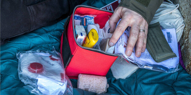 Eine Hand auf einer Prepper-Zubehör-Box, mit der ein Mann individuellen Katastrophenschutz betreibt. Eine Hand auf einer Prepper-Zubehör-Box, mit der ein Mann individuellen Katastrophenschutz betreibt.