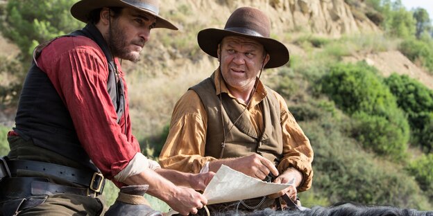 Joaquin Phoenix und John C. Reilly sitzen als Cowboys auf den Rücken ihrer Pferde Joaquin Phoenix und John C. Reilly sitzen als Cowboys auf den Rücken ihrer Pferde