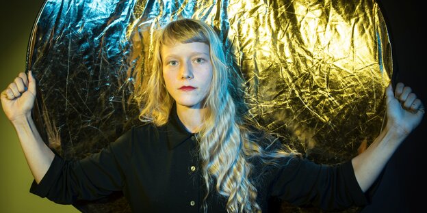 Straßenmusikerin Alice Phoebe Lou post vor einer goldenen Leinwand Straßenmusikerin Alice Phoebe Lou post vor einer goldenen Leinwand