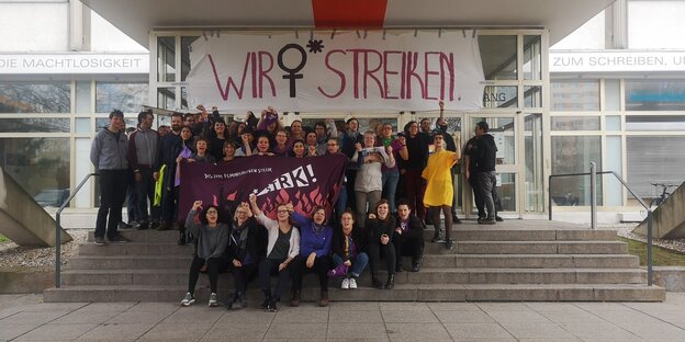 Vor einem Verlagsgebäude sind zahlreiche Frauen zu sehen, darüber hängt ein Transparent "Wir streiken" Vor einem Verlagsgebäude sind zahlreiche Frauen zu sehen, darüber hängt ein Transparent "Wir streiken"