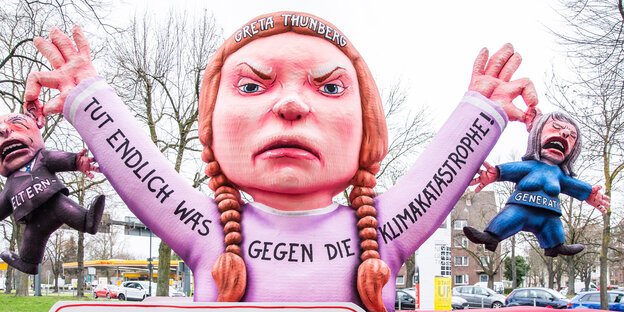 Ein Karnevalswagen stellt die junge schwedische Klimaaktivistin Greta Thunberg dar, die der Elterngeneration die Ohre langzieht Ein Karnevalswagen stellt die junge schwedische Klimaaktivistin Greta Thunberg dar, die der Elterngeneration die Ohre langzieht