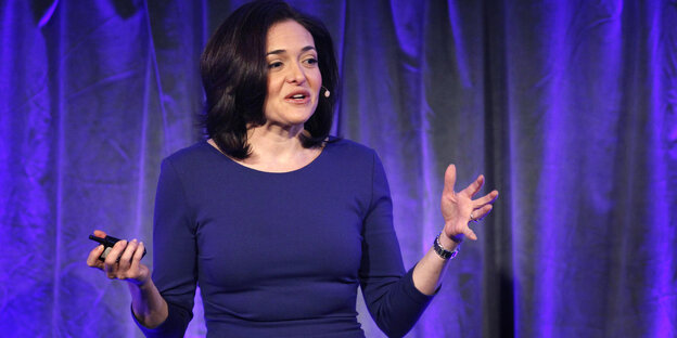 Sheryl Sandberg vor einem violetten Vorhang bei einer Präsentation Sheryl Sandberg vor einem violetten Vorhang bei einer Präsentation