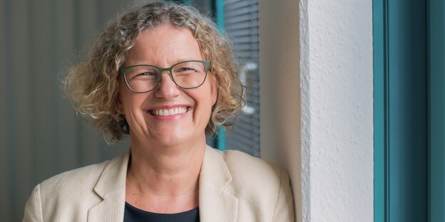 Eine Frau blickt lächelnd in die Kamera Eine Frau blickt lächelnd in die Kamera