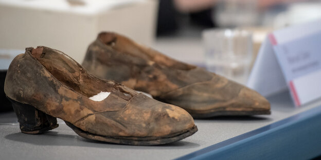 Ein paar Damenschuhe stehen bei einer Pressekonferenz auf einem Tisch Ein paar Damenschuhe stehen bei einer Pressekonferenz auf einem Tisch