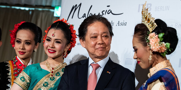 Drei Frauen und ein Mann vor einem Schild mit Aufschirft "Malaysia" Drei Frauen und ein Mann vor einem Schild mit Aufschirft "Malaysia"