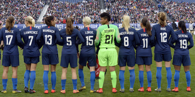Das US-Frauenfußballteam steht mit dem Rücken zur Kamera Das US-Frauenfußballteam steht mit dem Rücken zur Kamera