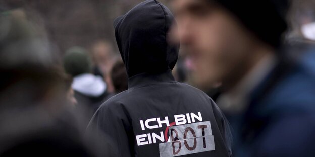Jemand mit einer Jacke, auf der steht: "Ich bin ein Bot" Jemand mit einer Jacke, auf der steht: "Ich bin ein Bot"