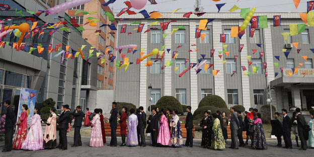 Nordkoreaner stehen im Rahmen der Wahl der Obersten Volksversammlung, des nordkoreanischen Parlaments, vor einem Wahllokal an, um ihre Stimme abgeben zu könne Nordkoreaner stehen im Rahmen der Wahl der Obersten Volksversammlung, des nordkoreanischen Parlaments, vor einem Wahllokal an, um ihre Stimme abgeben zu könne