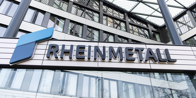 Das Firmenschild mit der Aufschrift Rheinmetall hängt vor einem Haus mit Stahlkonstruktion Das Firmenschild mit der Aufschrift Rheinmetall hängt vor einem Haus mit Stahlkonstruktion
