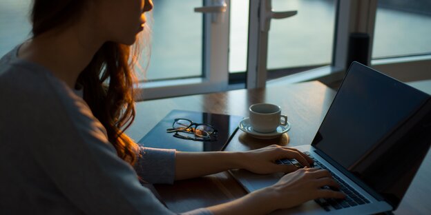 Ein Frau sitzt an einem Laptop