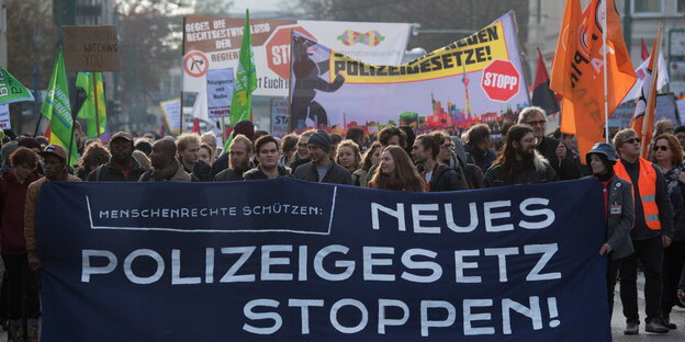 Demonstration gegen das Polizeigesetz: Demonstrantinnen und Demonstranten halten Banner und Fahnen und marschieren auf der Straße Demonstration gegen das Polizeigesetz: Demonstrantinnen und Demonstranten halten Banner und Fahnen und marschieren auf der Straße