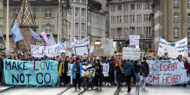 In Basel demonstrieren Menschen mit Schildern und Bannern während einer „Klimastreik“-Demonstration In Basel demonstrieren Menschen mit Schildern und Bannern während einer „Klimastreik“-Demonstration