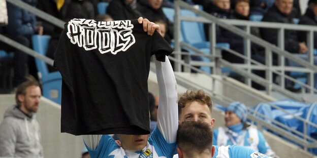 Ein Spieler des FC Chemnitz hält ein Hooligan-Tshirt in die Höhe Ein Spieler des FC Chemnitz hält ein Hooligan-Tshirt in die Höhe