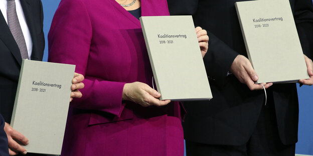 Drei Personen halten ein Buch Drei Personen halten ein Buch
