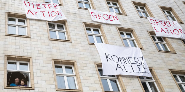Ein älteres Pärchen schaut aus dem Fenster in der Karl-Marx-Allee. Es hängen Transparente Ein älteres Pärchen schaut aus dem Fenster in der Karl-Marx-Allee. Es hängen Transparente