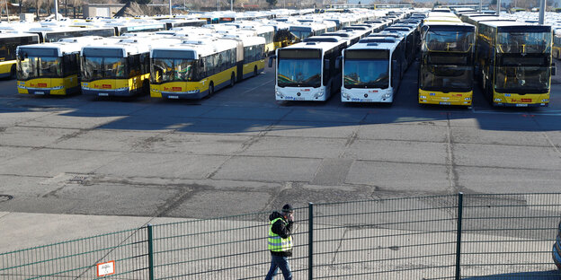 Viele Busse neben und hintereinander auf einem umzäunten Parkplatz Viele Busse neben und hintereinander auf einem umzäunten Parkplatz