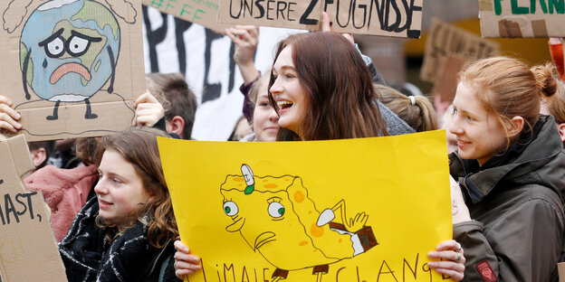 Junge Menschen mit selbst gemalten Protestplakaten