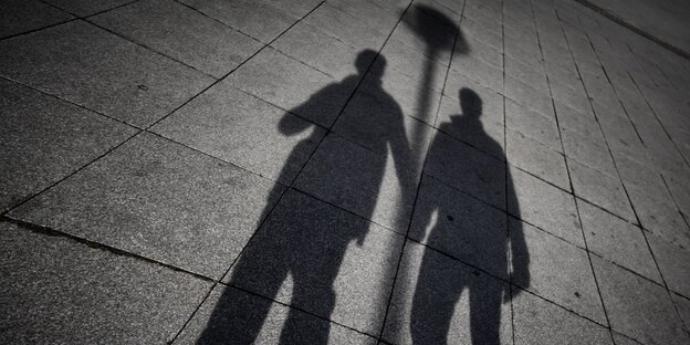 Die Schatten zweier Männer, die Hand in Hand gehen Die Schatten zweier Männer, die Hand in Hand gehen