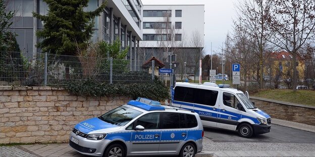 Polizeiautos vor einem Gerichtsgebäude Polizeiautos vor einem Gerichtsgebäude