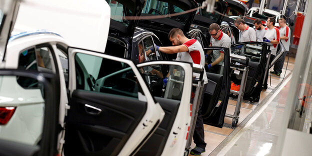 Menschen bauen Autos zusammen Menschen bauen Autos zusammen