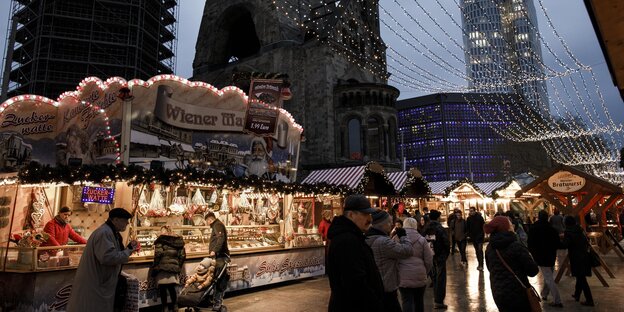 Besucher gehen über den Weihnachtsmarkt am Breitscheidplatz Besucher gehen über den Weihnachtsmarkt am Breitscheidplatz