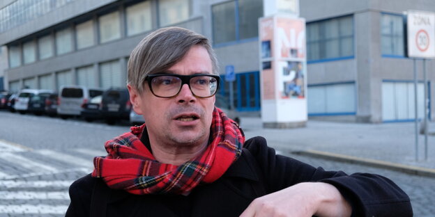 Schriftsteller Rudis gestikuliert vor einem Gebäude Schriftsteller Rudis gestikuliert vor einem Gebäude
