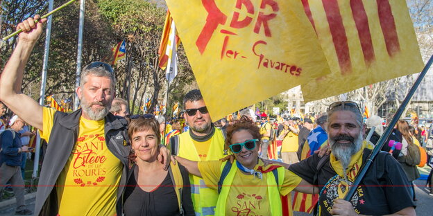 zwei Frauen und zwei Männer stehen Arm in Arm nebeneinander, im Hintergrund eine Demonstrationszug zwei Frauen und zwei Männer stehen Arm in Arm nebeneinander, im Hintergrund eine Demonstrationszug