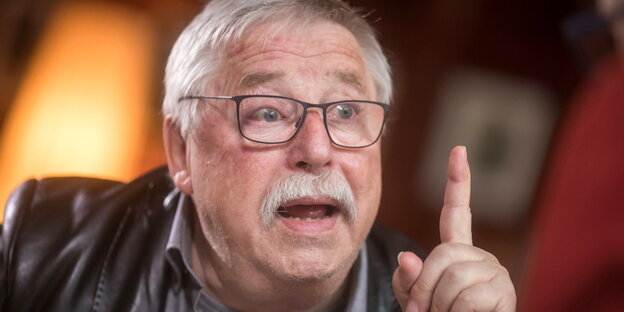 ein Mann mit erhobenem linken Zeigefinger ein Mann mit erhobenem linken Zeigefinger