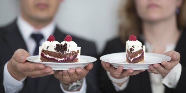 Ein Mann und eine Frau halten ein Stück Torte. Der Mann hat der größere Stück vom Kuchen Ein Mann und eine Frau halten ein Stück Torte. Der Mann hat der größere Stück vom Kuchen