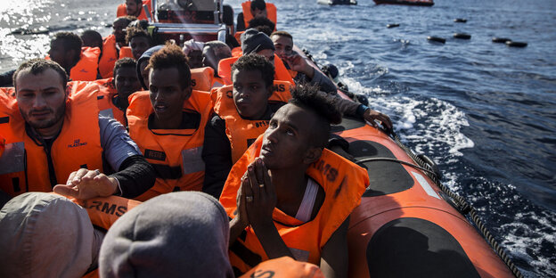 Menschen sitzen in einem Schlauchboot auf dem Mittelmeer Menschen sitzen in einem Schlauchboot auf dem Mittelmeer