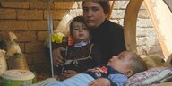 Eine Jesidin sitzt mit ihren Kindern in einem Flüchtlingscamp im Sindschar-Gebirge.