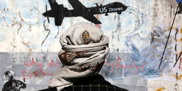 Ein Jemenit steht vor einem Graffiti, mit dem gegen US-Drohnenoperationen protestiert wird. Ein Jemenit steht vor einem Graffiti, mit dem gegen US-Drohnenoperationen protestiert wird.