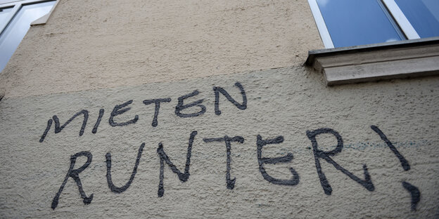 "Mieten runter!" steht als Graffito an einer grauen Hauswand "Mieten runter!" steht als Graffito an einer grauen Hauswand