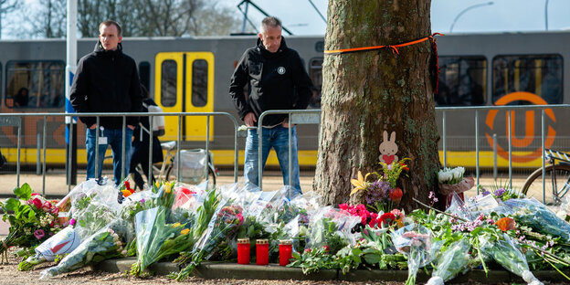 Zwei Männer vor Blumen an einer Straßenbahn Zwei Männer vor Blumen an einer Straßenbahn