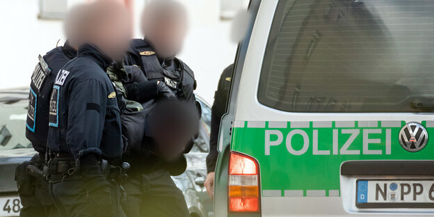 Einsatzkräfte der Polizei führen einen Mann ab