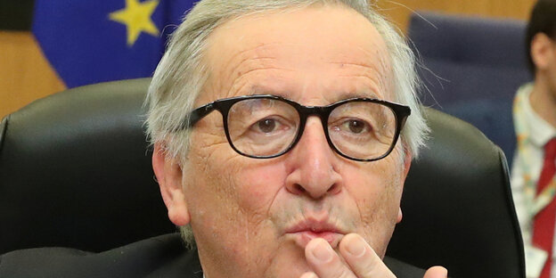 Jean-Claude Juncker spitzt seine Lippen und hält sich eine Hand vor den Mund Jean-Claude Juncker spitzt seine Lippen und hält sich eine Hand vor den Mund
