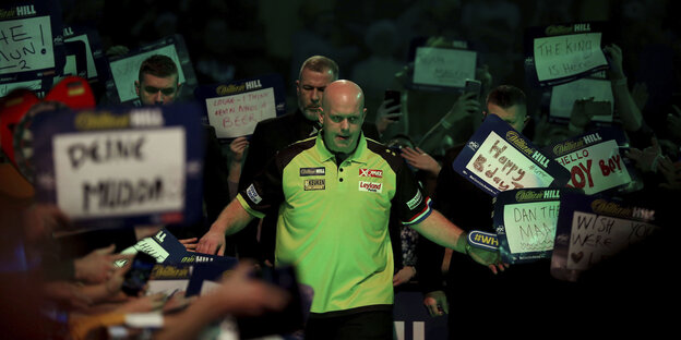 Ein Mann, Michael van Gerwen, mit Fans, die Schilder hochhalten Ein Mann, Michael van Gerwen, mit Fans, die Schilder hochhalten
