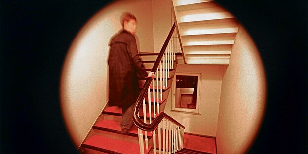 Eine Person geht durch ein Treppenhaus. Eine Person geht durch ein Treppenhaus.