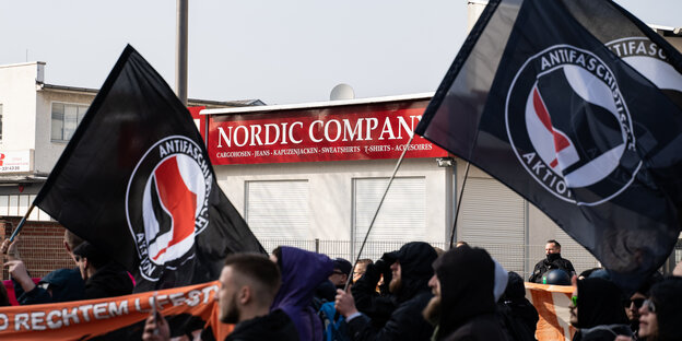 Antifa-Fahnen vor einem Thor-Steinar-Laden Antifa-Fahnen vor einem Thor-Steinar-Laden