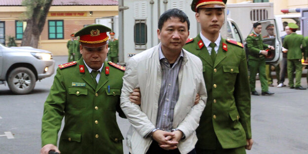 Der angeklagte Geschäftsmann Trinh Xuan Thanh wird von Polizisten zu einem Gericht gebracht. Der angeklagte Geschäftsmann Trinh Xuan Thanh wird von Polizisten zu einem Gericht gebracht.