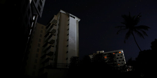 Gebäude im Dunkeln ohne Strom, nur wenige Fenster mit Kerzenlicht