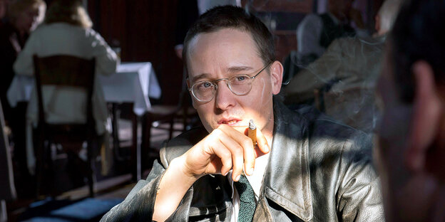 Ein Mann mit Brille raucht Zigarre Ein Mann mit Brille raucht Zigarre