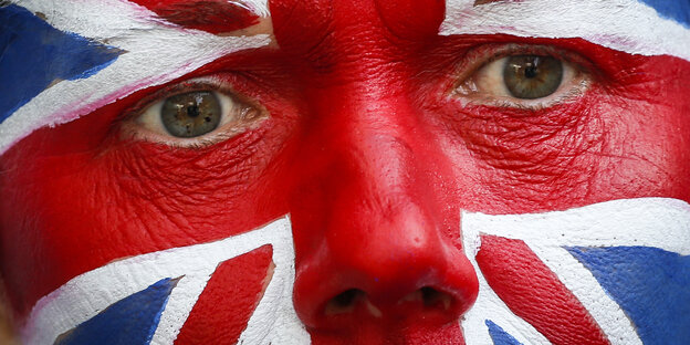 Ein Mann ist geschminkt in den Farben des Union Jack. Ein Mann ist geschminkt in den Farben des Union Jack.